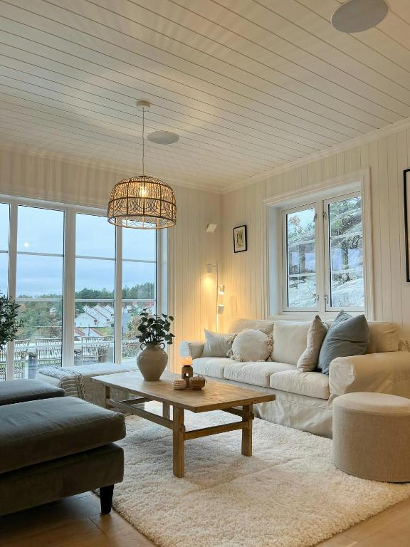 a living room with a couch and a table at Modern & Charming Summer House Near Risør in Søndeled