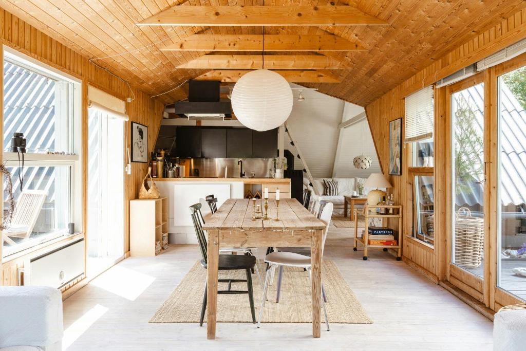 a dining room with a wooden table and chairs at Close To Beach, Forest And Bike Trails in Grenå