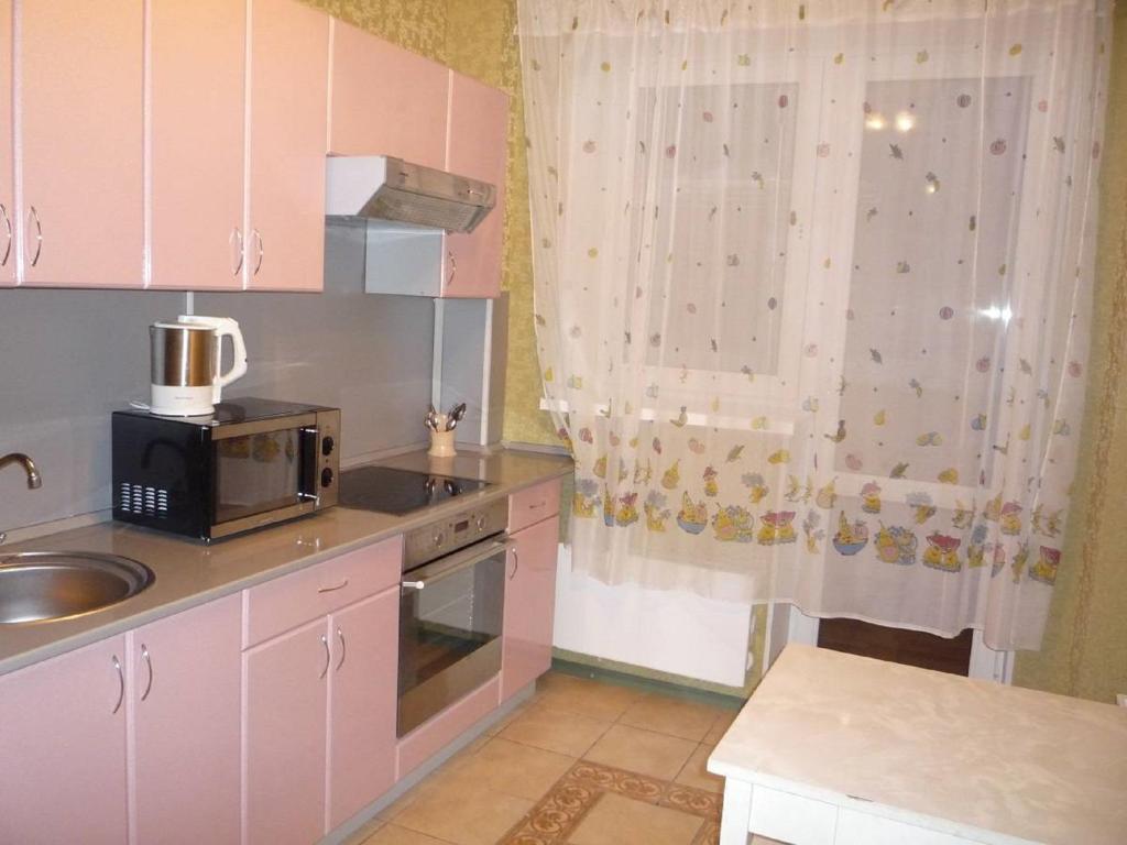 ウファにあるApartment Bakalinskaya 25の小さなキッチン(ピンクのキャビネット、電子レンジ付)