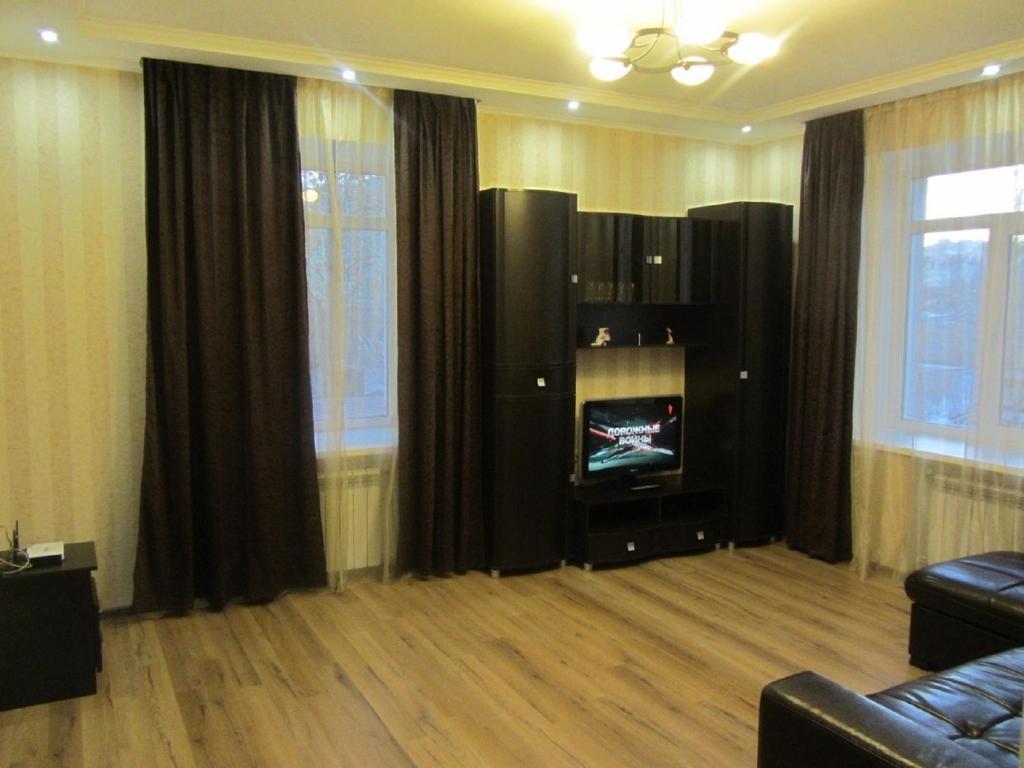 a living room with a couch and a tv at Apartment Lenina 9/11 in Ufa