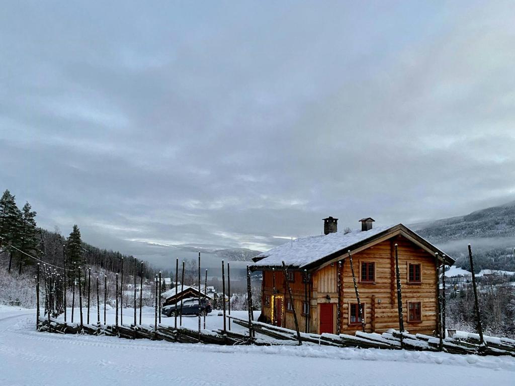 a wooden cabin with snow on it in the snow at Cabin With Wooden Interior By Lake Tinnsjøen in Atra