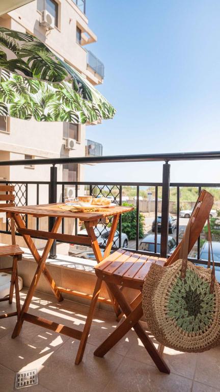 a wooden table and chairs on a balcony at Flat Lora Pomorie in Pomorie