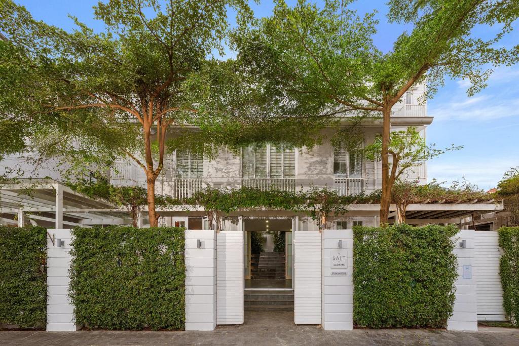 an entrance to a white house with trees at The Salt Villas Da Nang - 250sm 3BR, 4BA & Kitchen in Danang