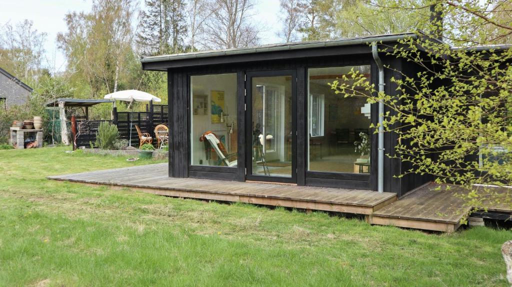 une cabine avec moustiquaire et terrasse en bois dans l'établissement Summer House Charm Near Hårbølle Havn, à Askeby
