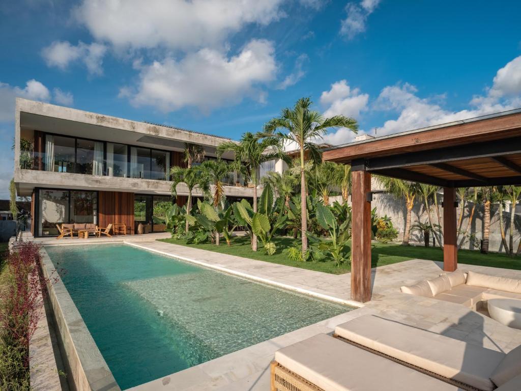 an exterior view of a house with a swimming pool at Villa Famara Pererenan, Canggu by Blacksand in Tumbak Bayuh