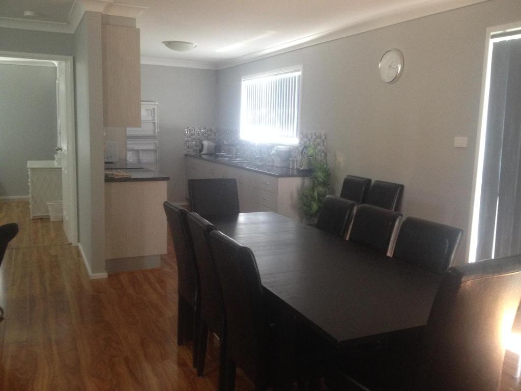 a dining room and kitchen with a table and chairs at Mystic Blue in Nowra