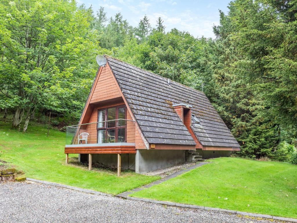 una pequeña casa con una ventana en el césped en Gorse Lodge - Uk7050, en Glenurguhart