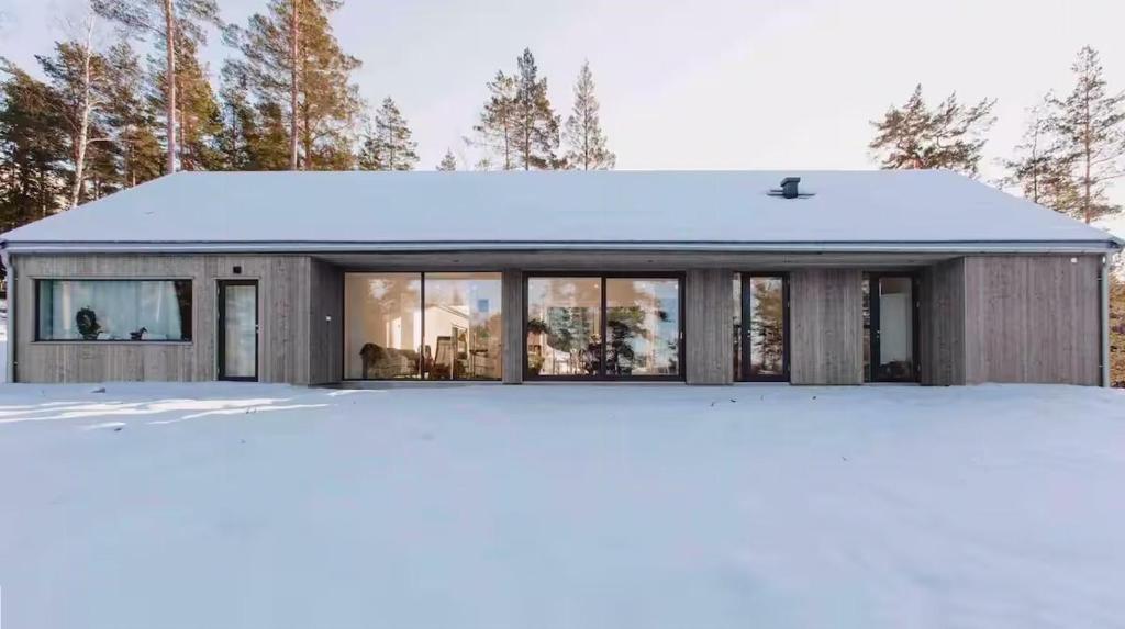 a house in the snow with a lot of windows at Your Archipelago Dream On Ingarö in Värmdö