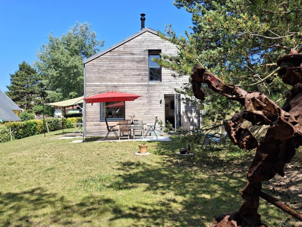une église avec une table et un parapluie rouge dans l'établissement Maison familiale 3 chambres à 300m de la plage - FR-1-788-81, à Merville-Franceville-Plage