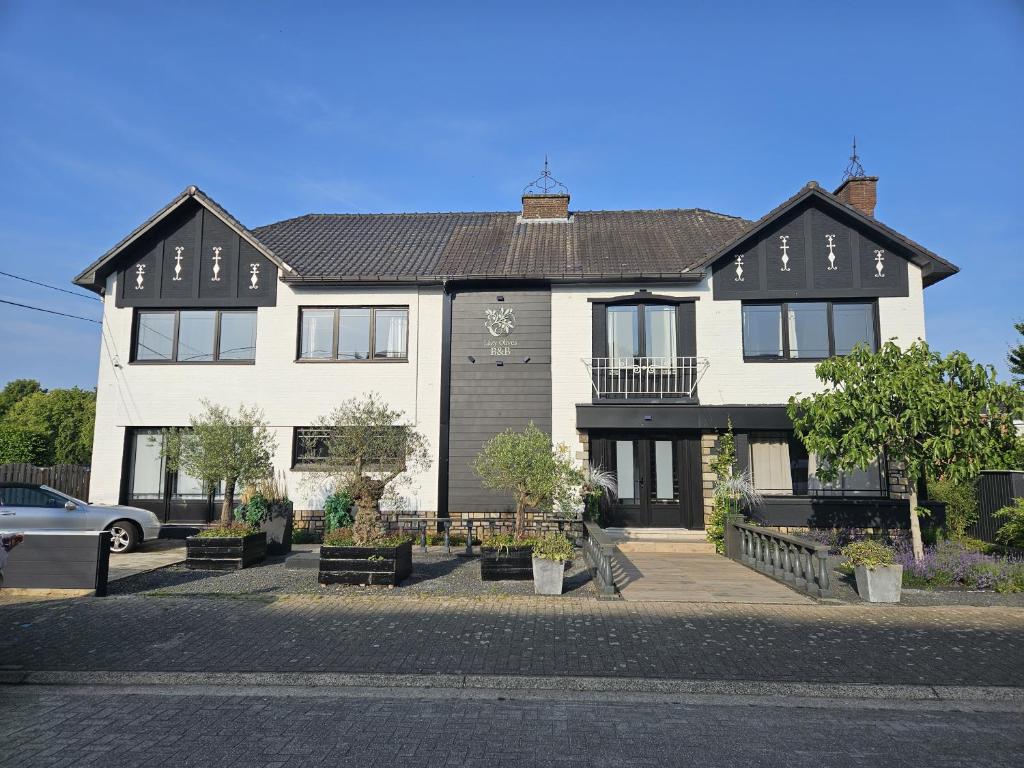 a white house with a black roof at Lazy Olives in Tongeren