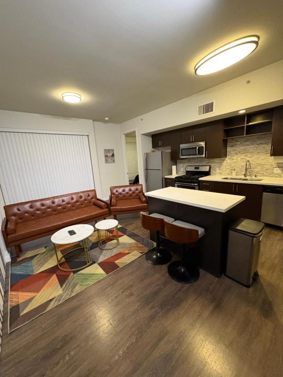 cocina con encimera, sillas y mesa en Poolside Palace, en Los Ángeles