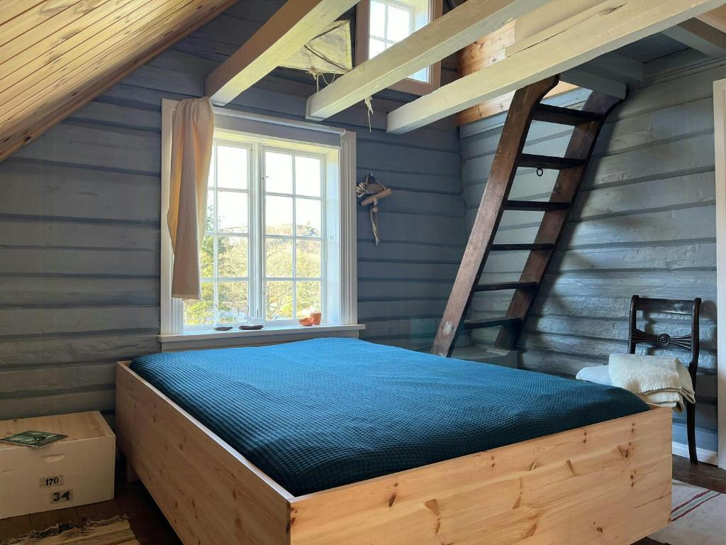 1 dormitorio con cama de madera en el ático en Idyllic Farmhouse From 1840 With Sea View In Spind, en Farsund