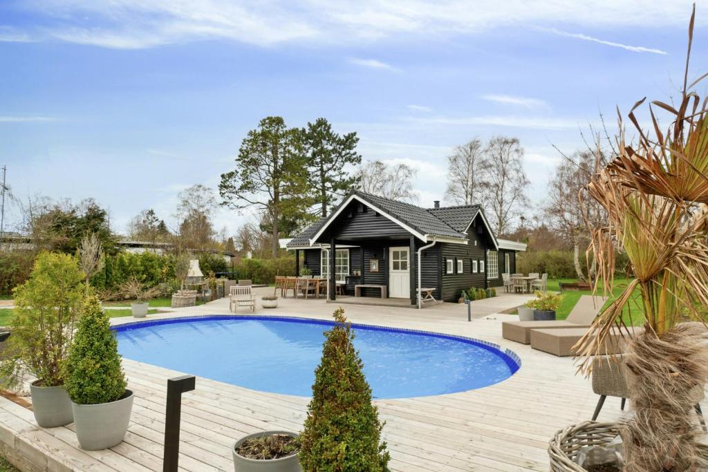 una casa con piscina di fronte a una casa di Bright Summer House With Pool In Tisvildeleje a Tisvildeleje