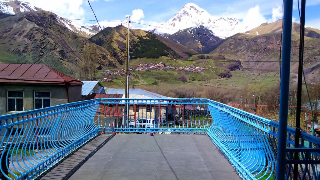 a blue bridge with a mountain in the background at Blue Guesthouse in Stepantsminda