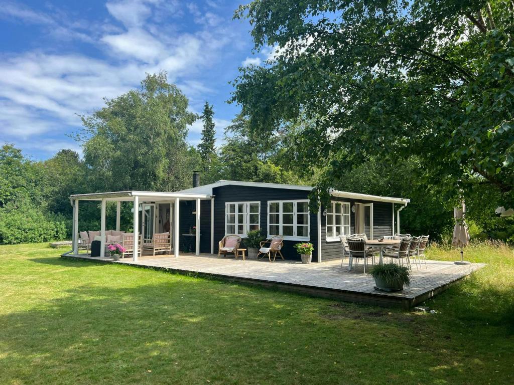 une maison avec terrasse dans une cour dans l'établissement Cottage Near Beach Perfect For Families, à Højby