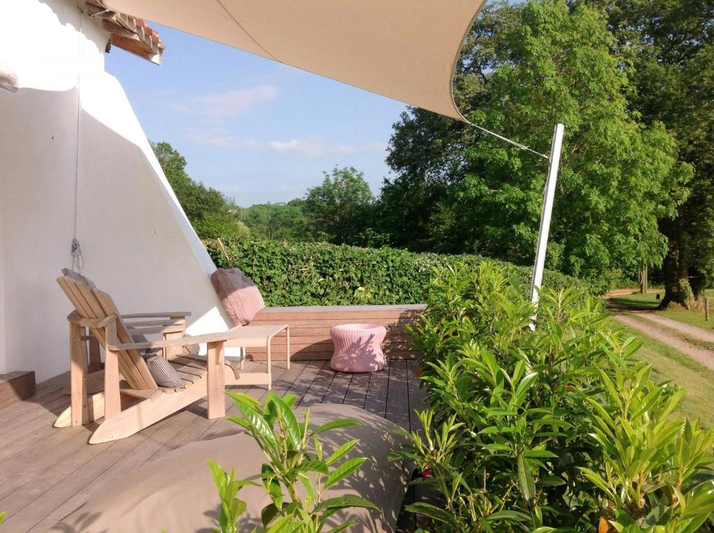 un patio avec deux chaises et un parasol dans l'établissement Basque Cottage With Views Of La Rhune Mountain, à Arcangues