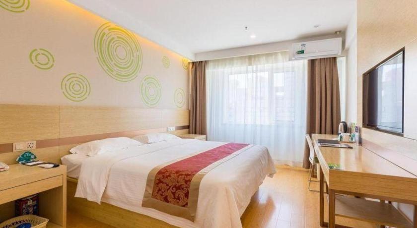 ein Hotelzimmer mit Bett und Schreibtisch in der Unterkunft GreenTree Inn Shenyang Shenhe District Wuai Street in Shenyang