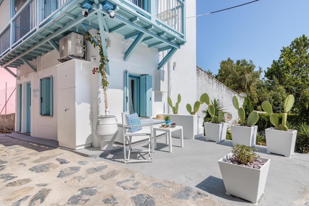a patio with potted plants and a table and chairs at Le Petit Bati Blue in Skopelos Town