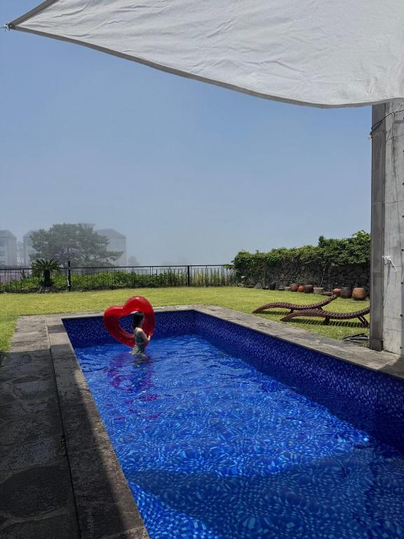 a person in a swimming pool with a red raft at Ocean View Private Pool Villa in Jeju