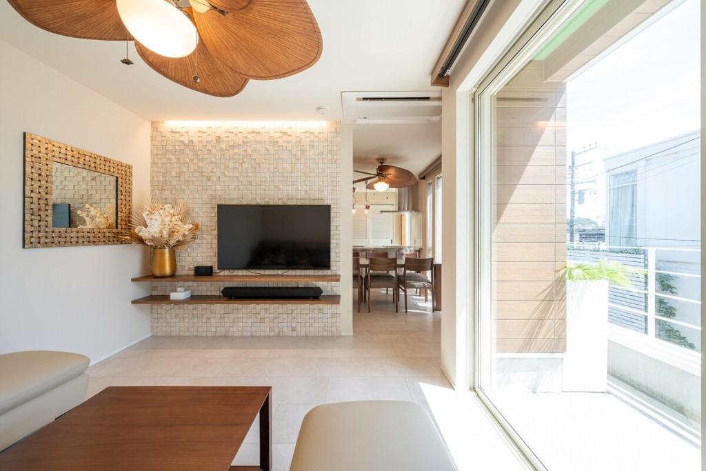 a living room with a fireplace and a television at Villa NiuHale in Fujisawa