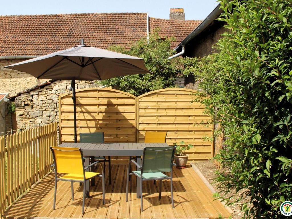 une table et des chaises avec un parasol sur une terrasse dans l'établissement Gîte familial rénové avec jardin au cœur de la Vallée de la Saône - FR-1-583-467, à Gourgeon