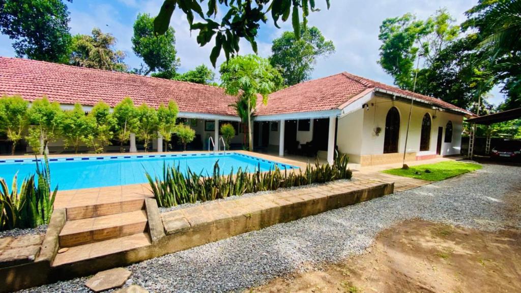 a house with a swimming pool in front of it at AYUBO Villa in Negombo