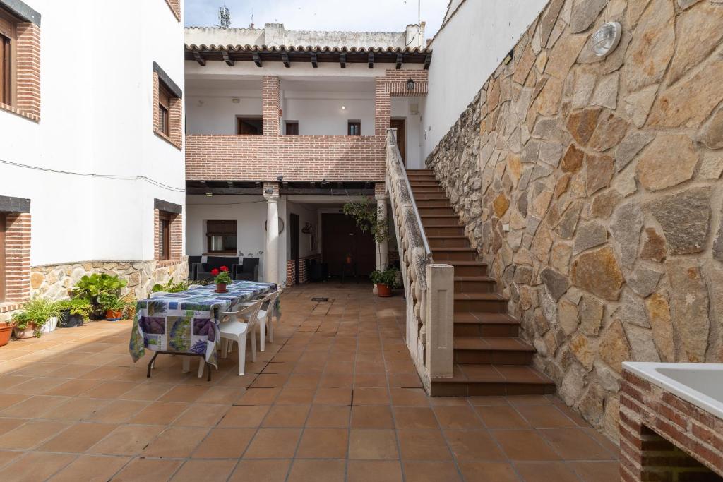 a patio with a table and a stone wall at Casa Rural La Abubilla in Valdelaguna