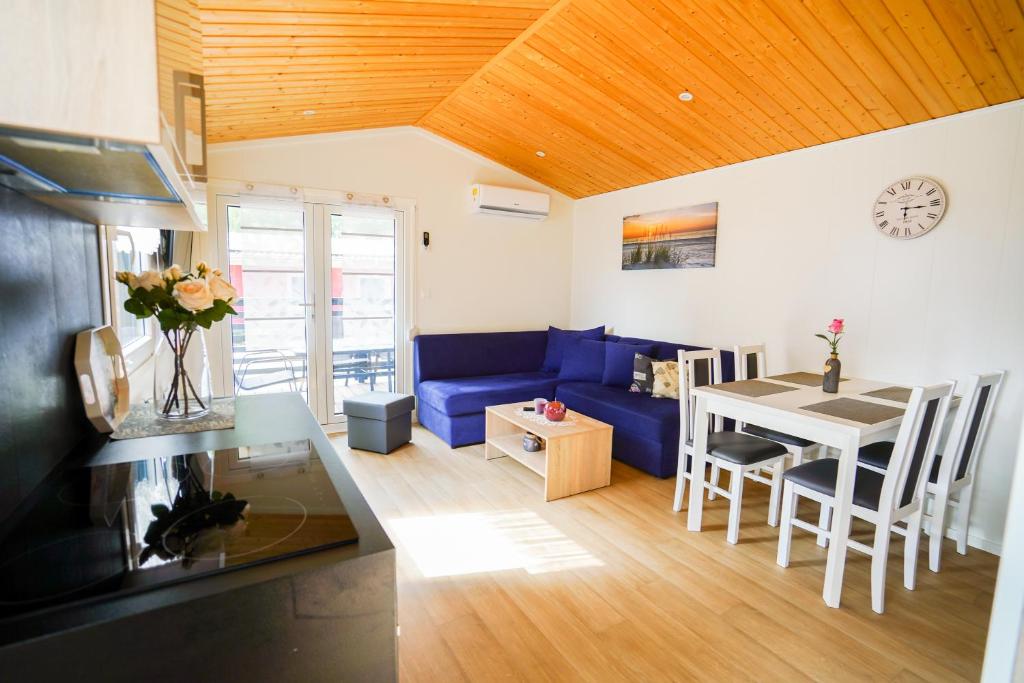 a living room with a blue couch and a table at Mobilheim 3 in Lohmen