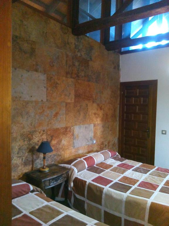 A bed or beds in a room at Casa Rural Hidalgo