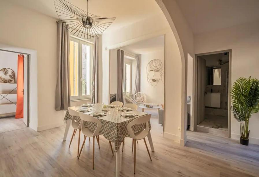 une salle à manger blanche avec une table et des chaises dans l'établissement Cocon des halles - Climatisation - Terrasse, à Narbonne