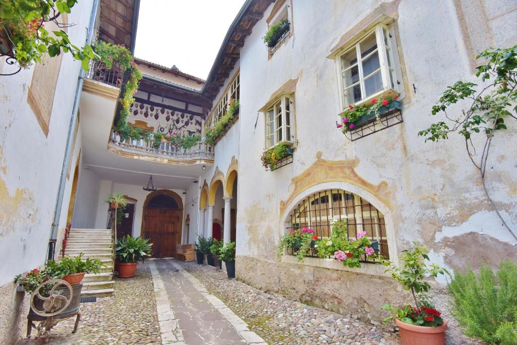 an alley in an old house with flowers in the window at Villa Bertagnolli - Locanda Del Bel Sorriso in Trento