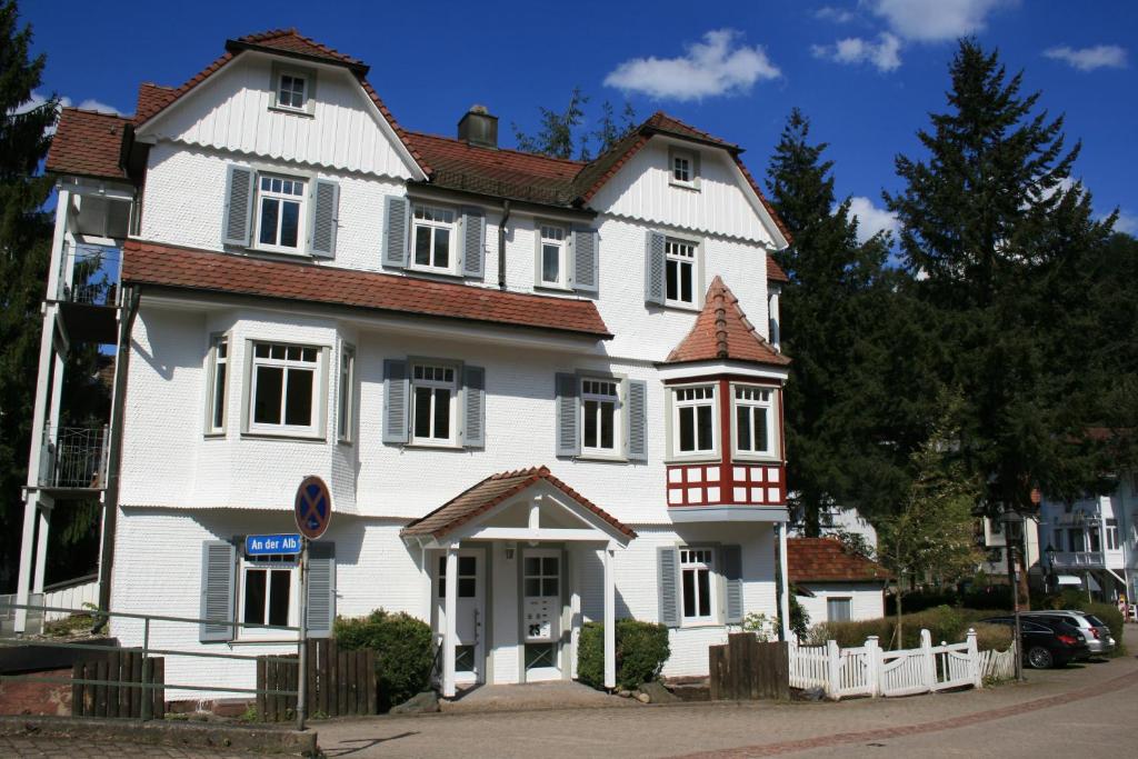 een groot wit huis met een rood dak bij Gästehaus Villa Lina in Bad Herrenalb