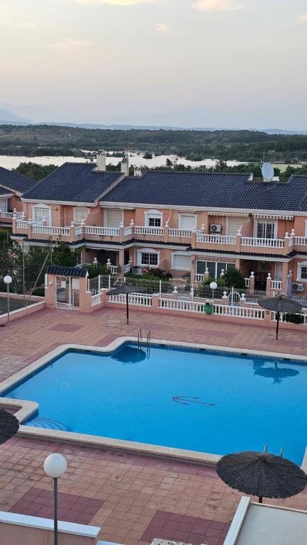 Una gran piscina azul frente a un edificio en Apartamento Carabassi, en Alicante