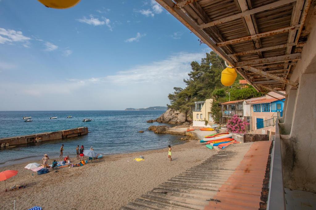 une plage avec des gens sur le sable et l'eau dans l'établissement Porte Rouge 5, au Pradet