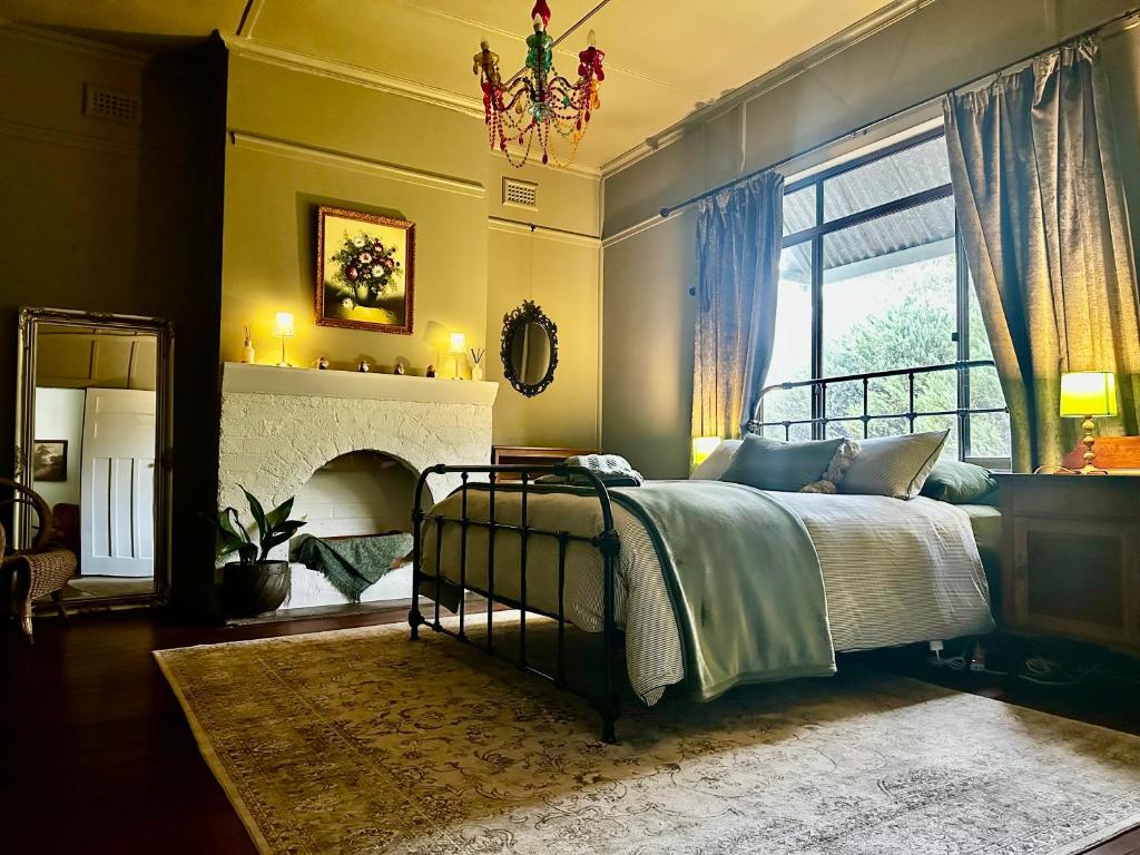 une chambre avec un lit et une cheminée dans l'établissement Hilltop Cottage, à Bridgetown