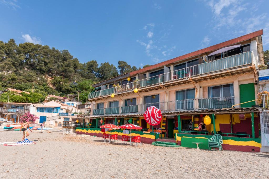 un hôtel sur la plage avec des chaises et des parasols dans l'établissement Porte Rouge 3, au Pradet
