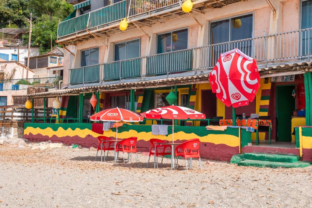 ein Strand mit Stühlen und Sonnenschirmen vor einem Gebäude in der Unterkunft Porte Rouge 3 in Le Pradet