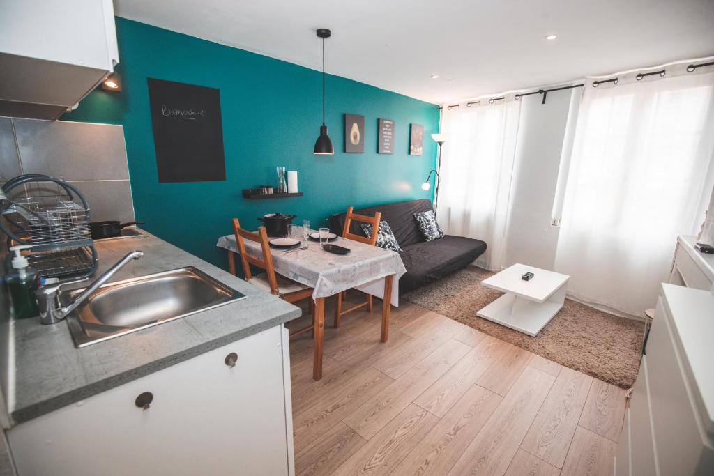 une cuisine et un salon avec une table et un canapé dans l'établissement Studio moderne tout équipé au pied des monuments, au Puy-en-Velay