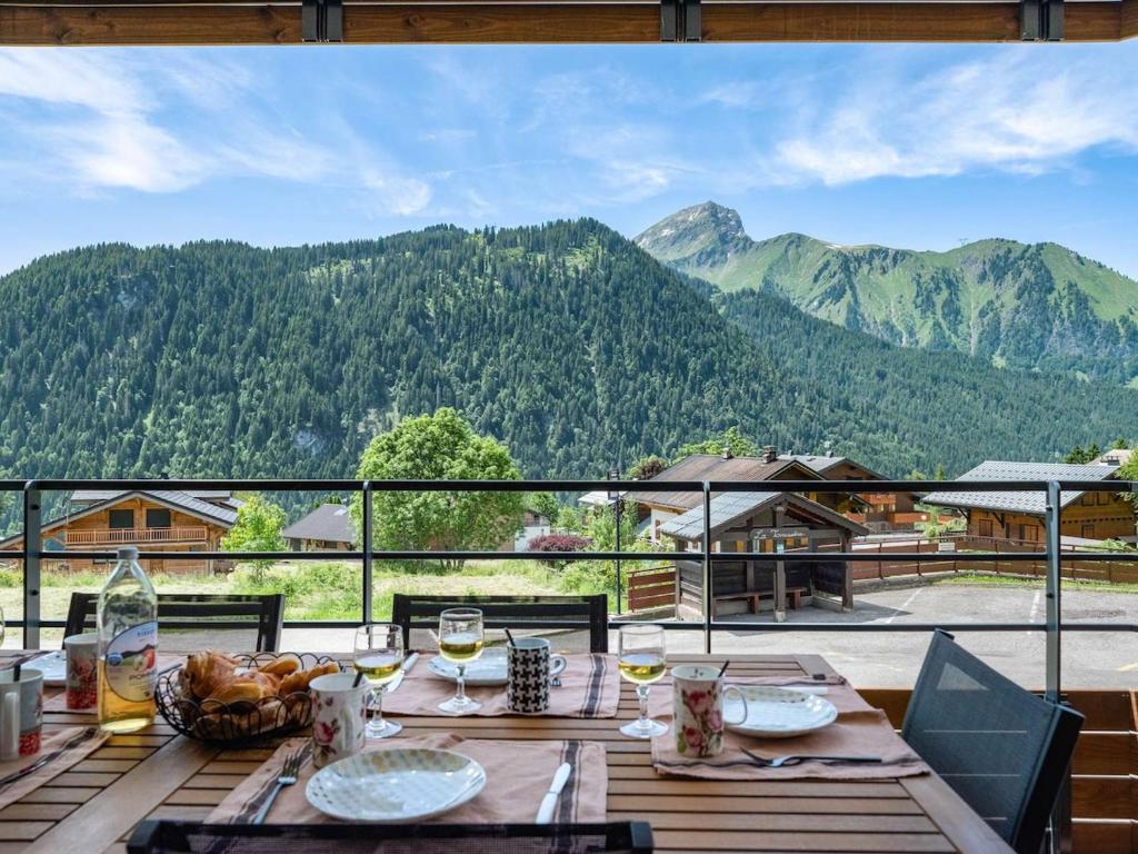 une table en bois avec vue sur les montagnes dans l'établissement Apt Art Mony 107 - BO Immobilier - Chatel, à Châtel