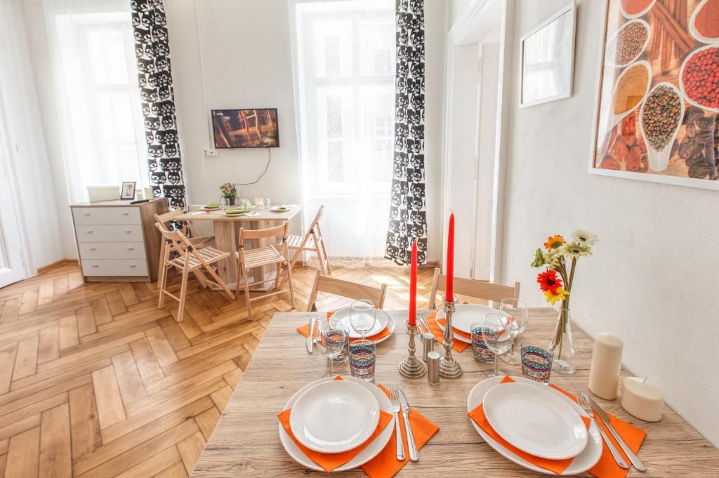 een eetkamer met een tafel met borden en kaarsen bij Modern Apartment Zitna in Praag