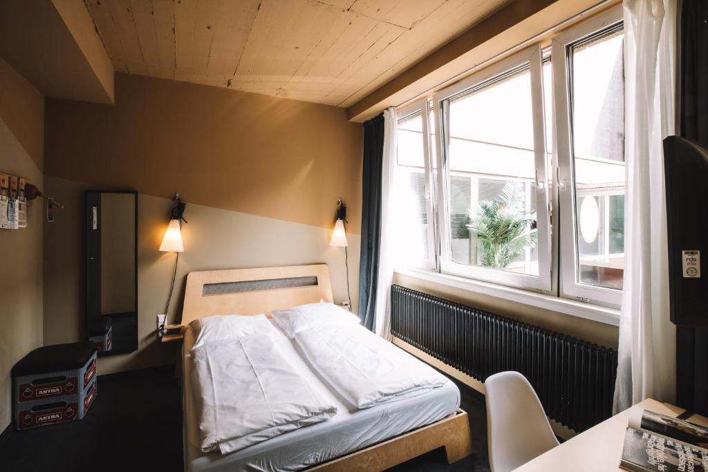 una piccola camera da letto con un letto e una finestra di Superbude Hamburg St Georg ad Amburgo