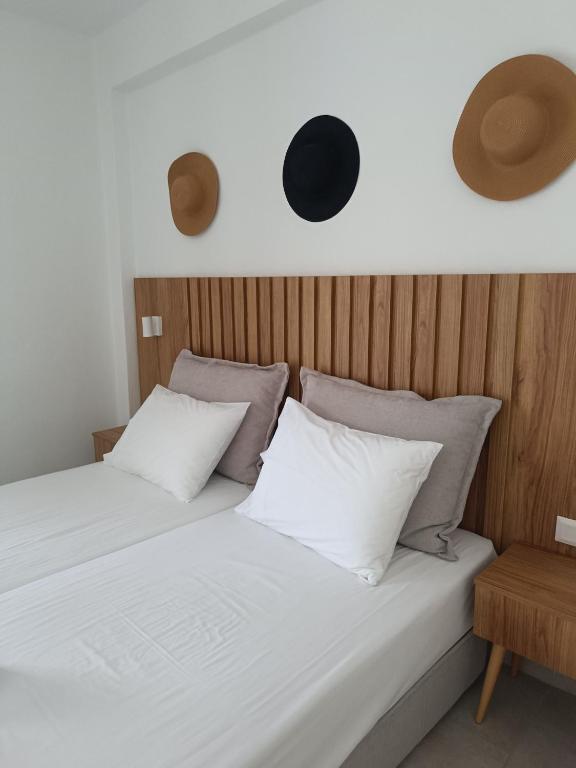 a bed with white sheets and pillows in a room at Milies Apartments in Stavros