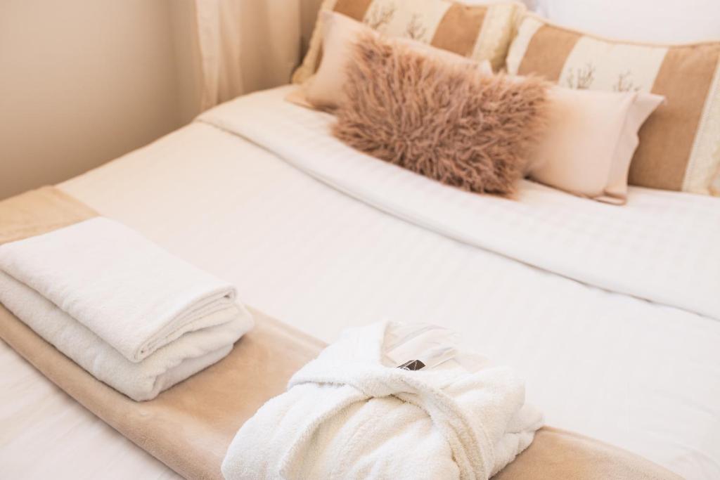 a bed with white towels and pillows on it at Chambre Aéroport 8 min à pied in Hangenbieten