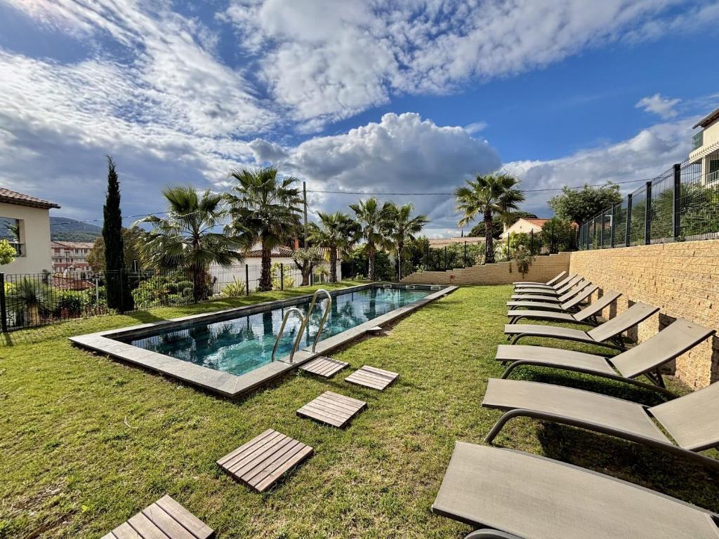 - une piscine avec des chaises longues dans la pelouse dans l'établissement Angeline, à Sainte-Maxime