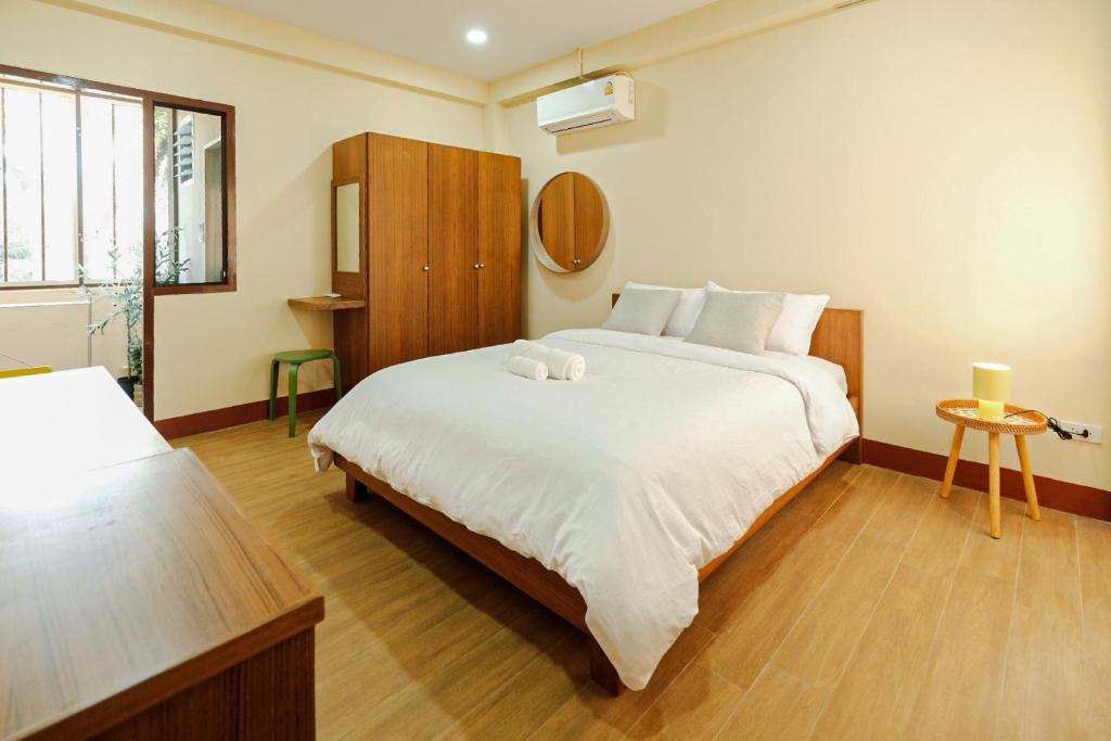 a bedroom with a large white bed and a window at Thong Poon Apartment Chiang Mai in Chiang Mai