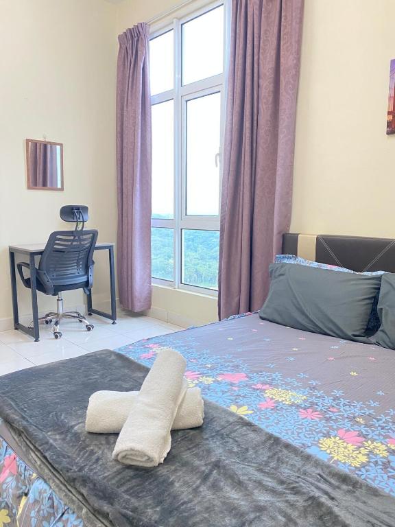 a bedroom with a bed with two towels on it at Apartment Deluxe Mesahill Nilai in Nilai