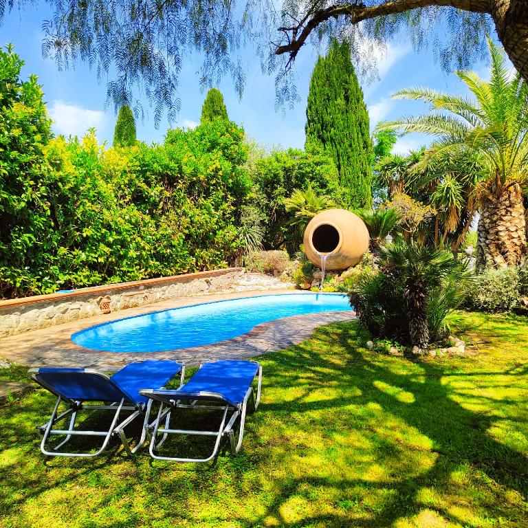 a yard with two chairs and a swimming pool at Casale dei Villa villa with pool and private parking in Ciampino