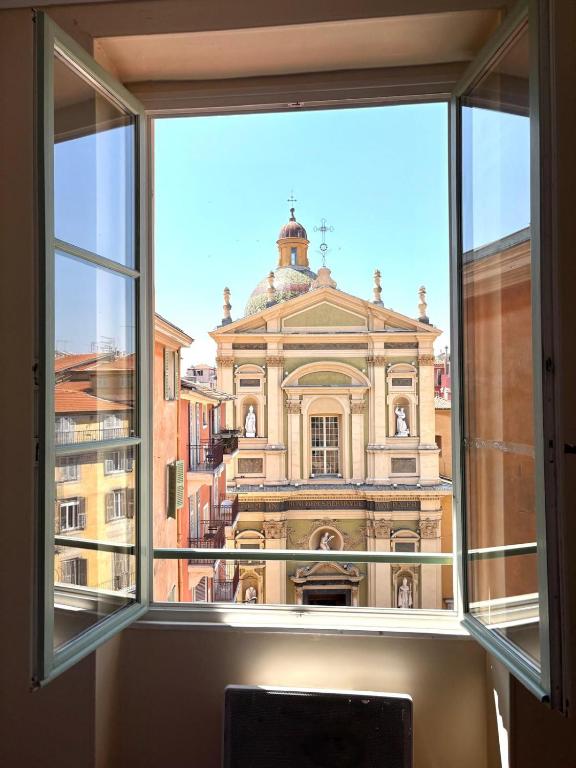 une grande fenêtre avec vue sur un bâtiment dans l'établissement STE REPARATE - Cosy 2 pieces vue cathedrale, à Nice