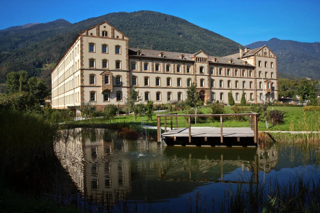 a large building sitting next to a body of water at Bischöfliches Institut Vinzentinum in Bressanone