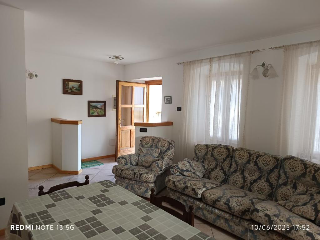 een woonkamer met een bank en een tafel bij Casa Montagna in Canale San Bovo